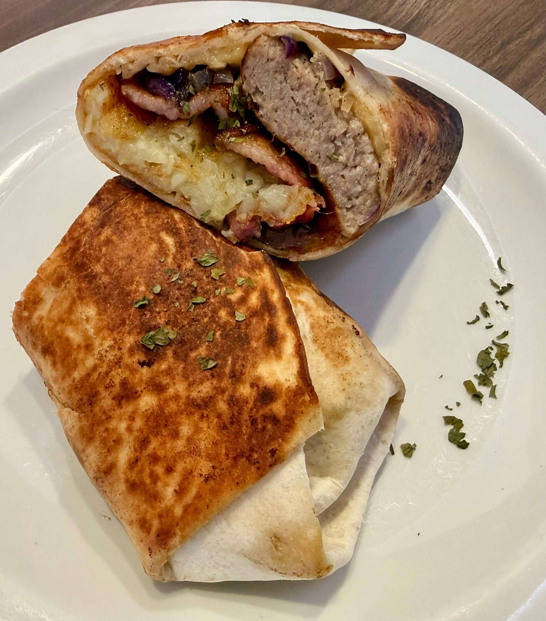 Toasted breakfast burrito sliced in half and served on a plate, showcasing the hearty food available at Scooters Café.