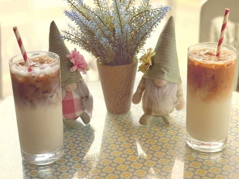 Bouquet of dried flowers displayed on a café table beside drinks and decorative items.
