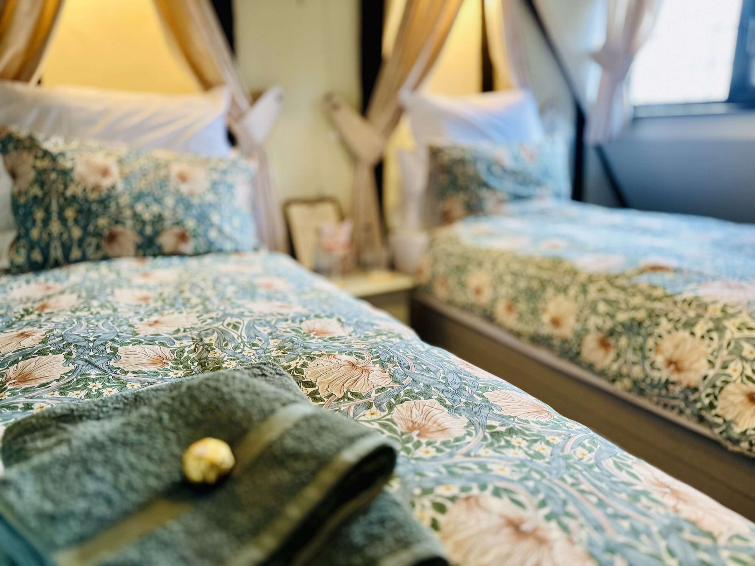 Danegelts twin bedroom with neatly dressed beds and soft furnishings.