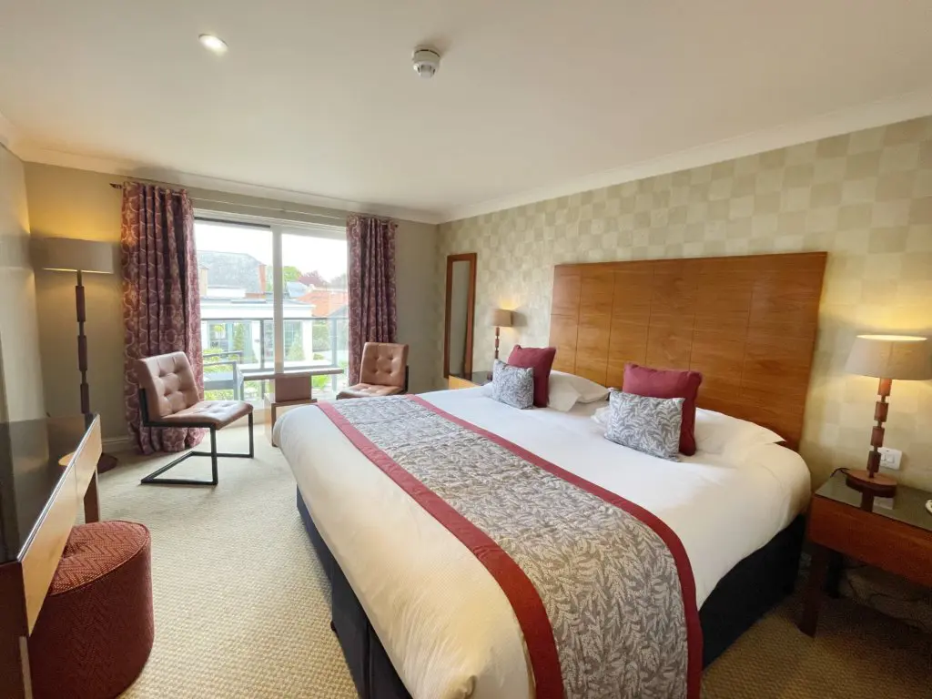 Spacious guest bedroom with modern furnishings at Park Farm Hotel.