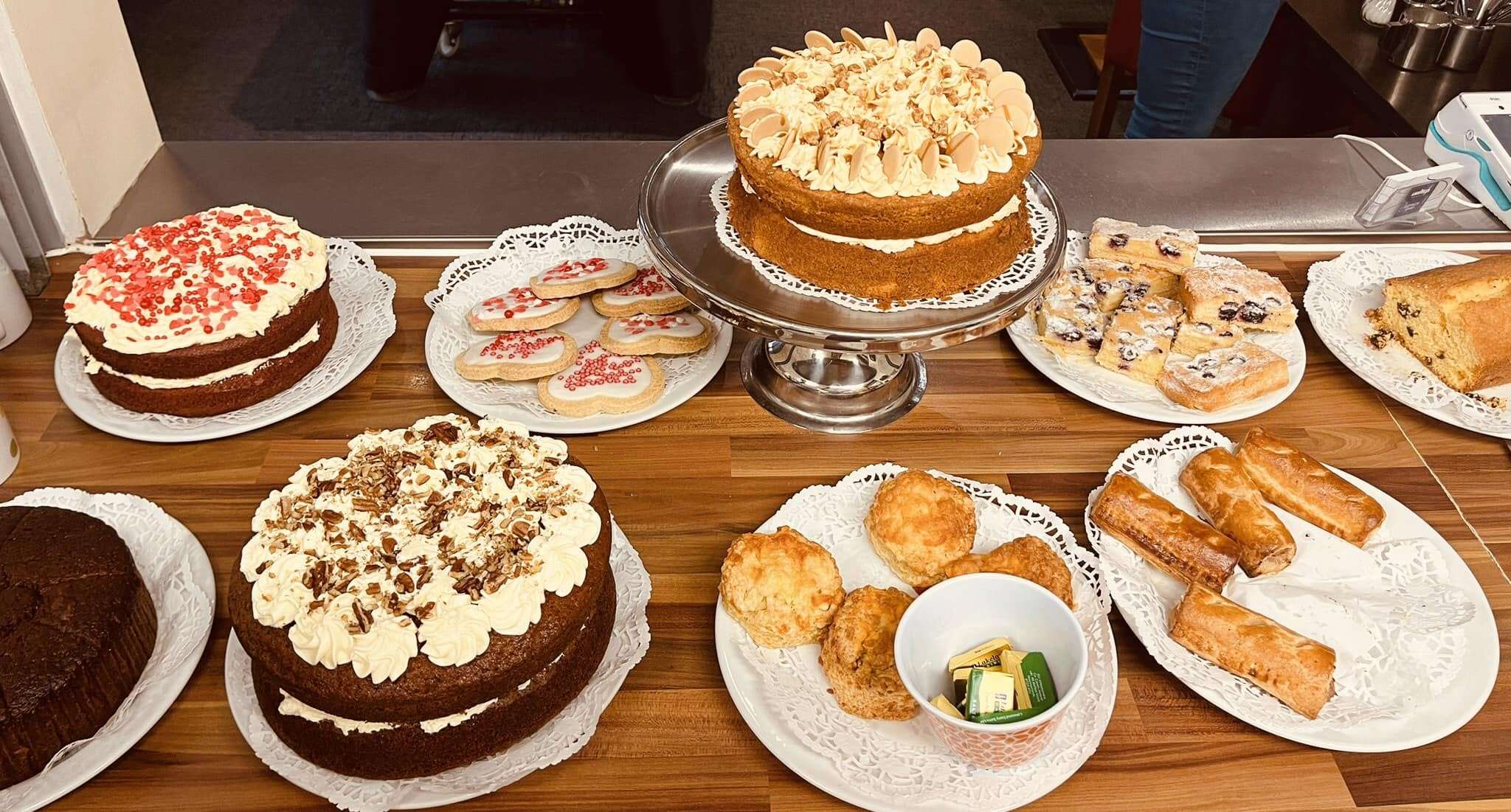 Selection of homemade cakes, traybakes and sweet treats displayed on a serving table at Hug a Mug Café in Lingwood.