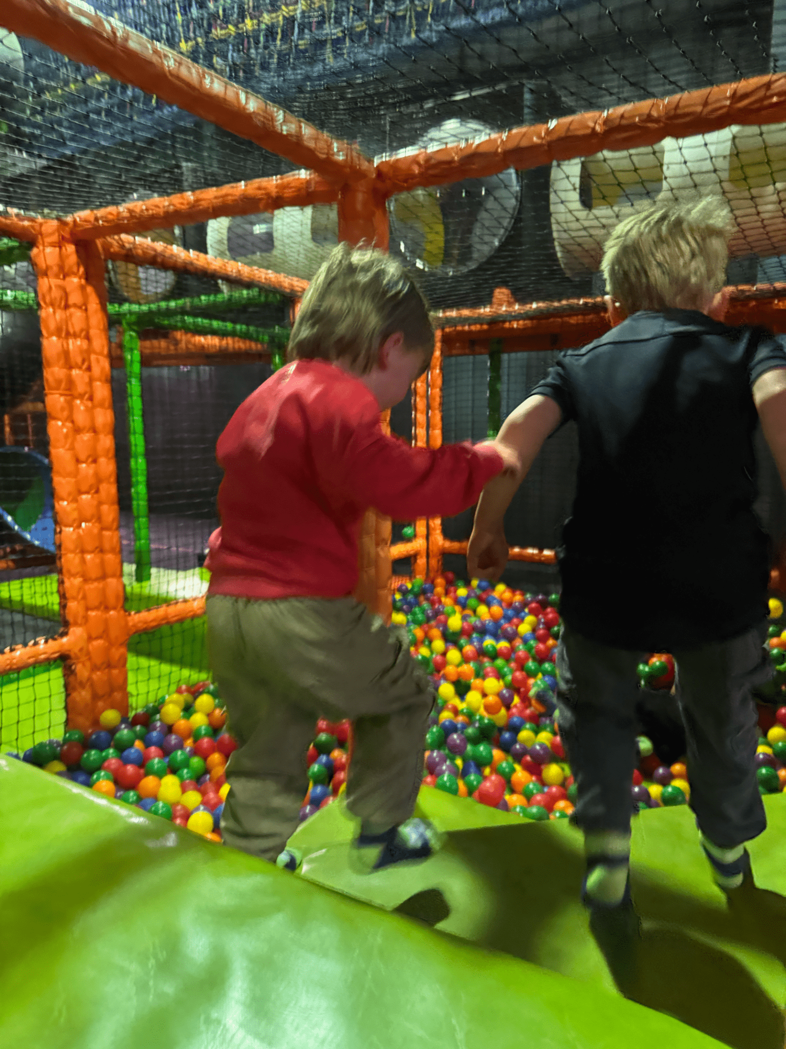 Children playing in the ball pond at High Altitude indoor activity centre, surrounded by soft play structures and padded obstacles.