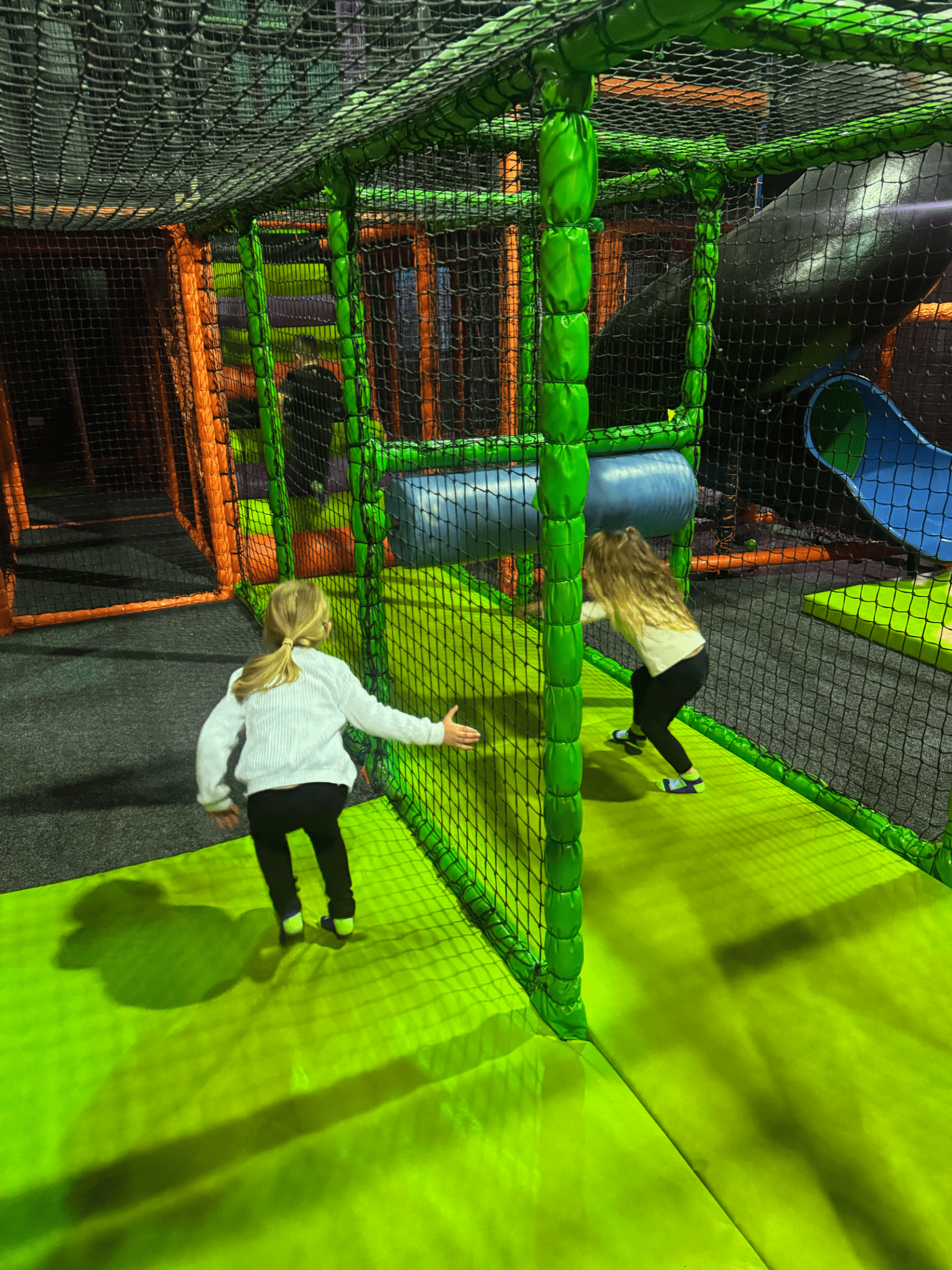 Children exploring the colourful soft play area at High Altitude, featuring climbing frames, tunnels, slides and interactive play equipment.