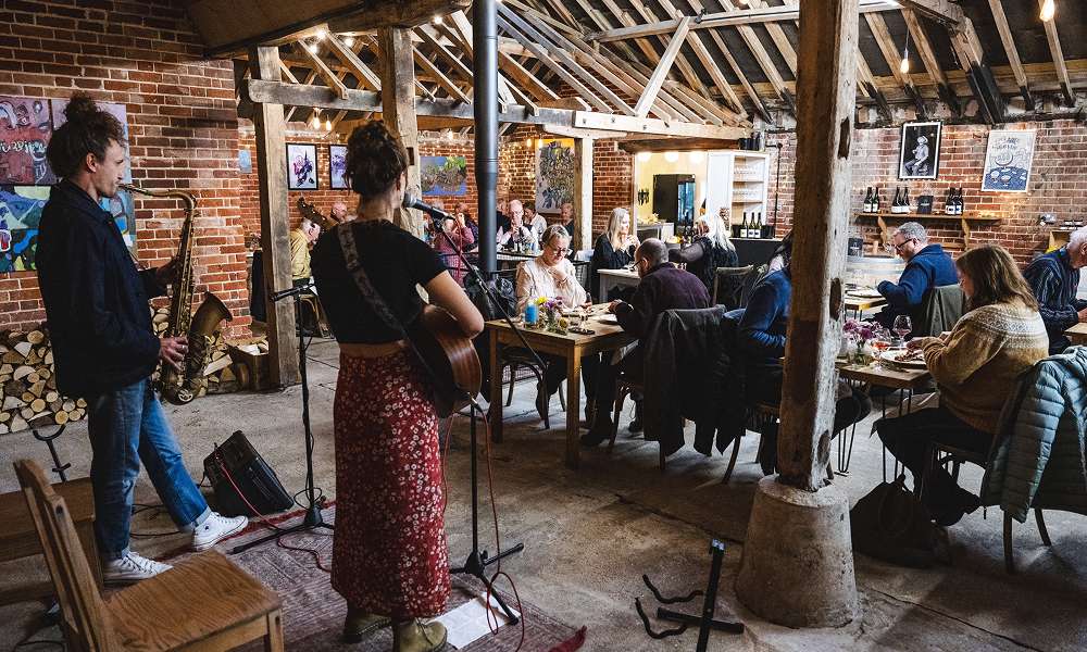 Guests gathered inside a rustic winery barn for a wine tasting or vineyard event, showcasing the venue's welcoming atmosphere.